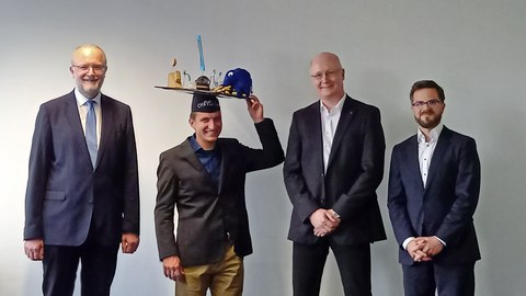 Christian Krüger mit Doktorhut, umgeben von Promotionskommision