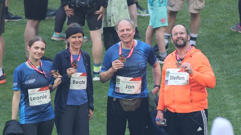 Das Mixed-Team des IMF nach dem Lauf. Alle 4 Teilnehmenden halten ihre Medallien hoch.