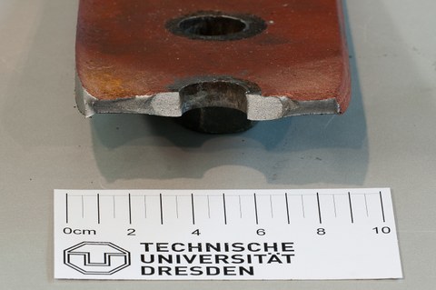 Brittle crack on the edge of a punched rivet hole, embrittlement due to strain ageing