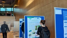 Eine Konferenzteilnehmerin liest sich das BIBOB-Poster durch.
