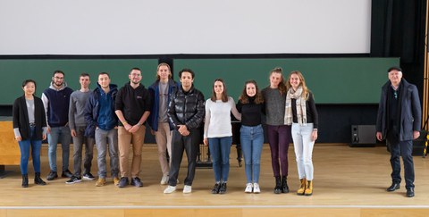 Alle Studierenden des Doppeldiplomprogramms stehen zu einem Gruppenbild auf der Bühne des Hörsaals