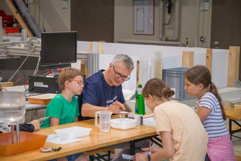 Kinder basteln an einem Stand