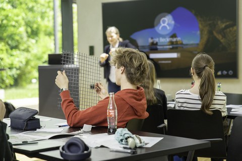 Schüler betrachte ein Gelege aus Carbonfasern