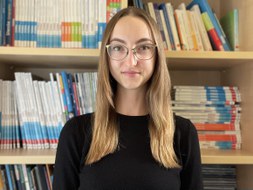 Auf dem Foto ist Ariane Schneider als Portrait zu sehen, der Hintergrund zeigt Bücherregale mit Lehrbüchern.