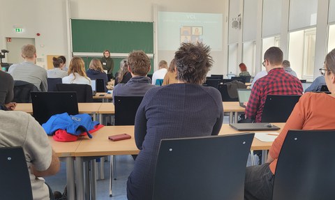 Referent:in steht vor dem Auditorium.