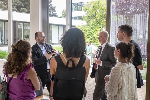 Diverse group engaged in lively discussion next to an open window