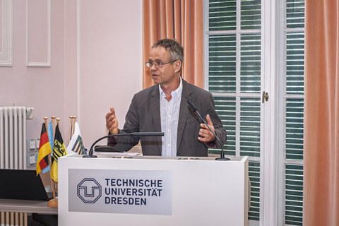 Prof. Dr. Karsten Kalbitz stands at the lectern of TU Dresden addressing the event participants.
