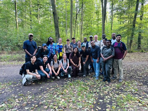 Gruppenfoto im Wald, Teilnehmende in 2 Reihen.
