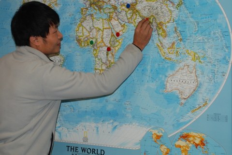 Ein Teilnehmer markiert sein Heimatland auf einer großen Weltkarte
