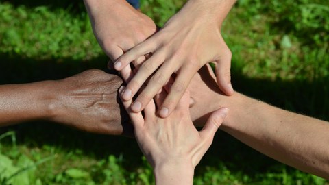 Hände, die sich berühren als Zeichen für Zusammenarbeit