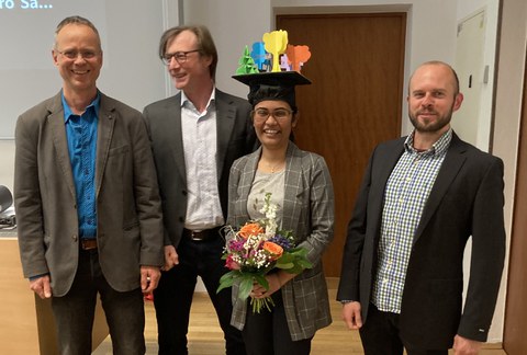 Tama Ray mit Doktorhut und ihren Betreuern