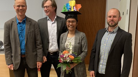 Tama Ray mit Doktorhut und ihren Betreuern