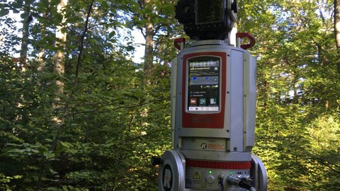 Ein Laserscanner steht auf einer bewaldeten Untersuchungsfläche
