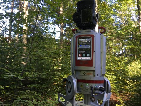Ein Laserscanner steht auf einer bewaldeten Untersuchungsfläche