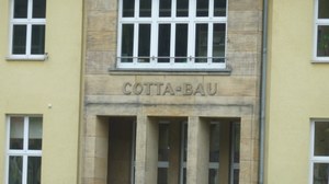 The photo shows the lettering COTTA-BAU above the entrance area of ​​the building mentioned