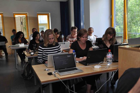 Kursteilnehmer arbeiten im Kursraum an ihren Laptops