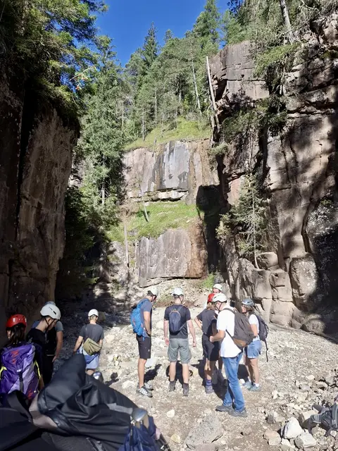 Die Bletterbachschlucht sowie ein paar Menschen mit Kletterausrüstung sind zu sehen.