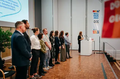 Teilnehmende der Konferenz auf der Bühne