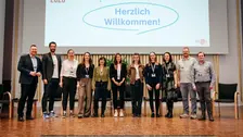 Teilnehmende der Konferenz auf der Bühne