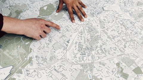 Personen zeigen auf eine Stadtkarte Leipzigs