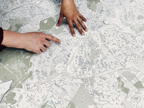 Personen zeigen auf eine Stadtkarte Leipzigs