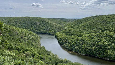 Fluss zwischen bewaldeten Hügeln