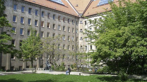 Rückseite des Hülße-Baus der TU Dresden. Im Innenhof befindet sich eine große Wiese und einige Bäume.