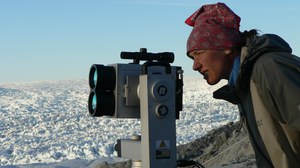 woman close to a glacier with a camera