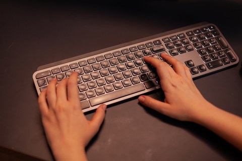 close up hands gamer pushing keyboard buttons while playing