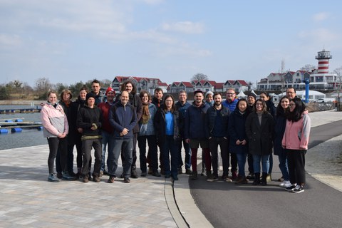 Gruppenbild der Arbeitsgruppe Limnologie am Geierswalder See mit Leuchtturm im Hintergrund