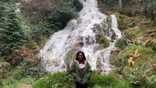 Projektpartnerin steht vor Wasserfall
