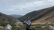 Projektpartnerin stehtauf Hügel, im Hintergrund Flussverlauf und Herbstlandschaft