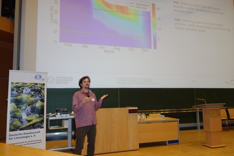Johannes Feldbauer präsentiert Ergebnisse an einer großen Leinwand. 