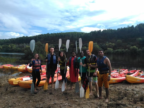 Students with Kayaks and corresponding outfits standing at the ocean somewhere in Portugal.