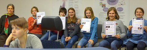 Schülerinnen zeigen ihre Zertifikate vom Bahnfahrsimulator