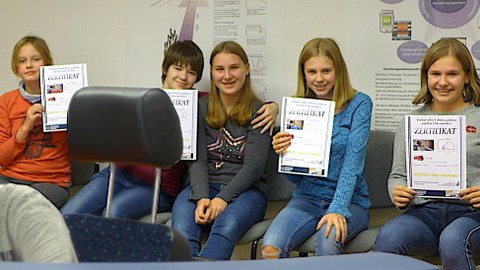 Schülerinnen zeigen ihre Zertifikate vom Bahnfahrsimulator