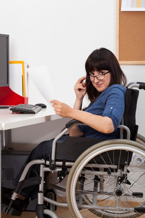 Frau im Rollstuhl am Schreibtisch