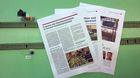 Drei Zeitschriftenartikel liegen auf der Laboranlage.