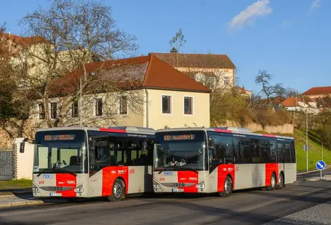 Zwei rot-weiße Regionalbusse des Verkehrsverbunds Mittelböhmen stehen nebeneinander.