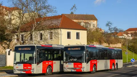 Zwei rot-weiße Regionalbusse des Verkehrsverbunds Mittelböhmen stehen nebeneinander.