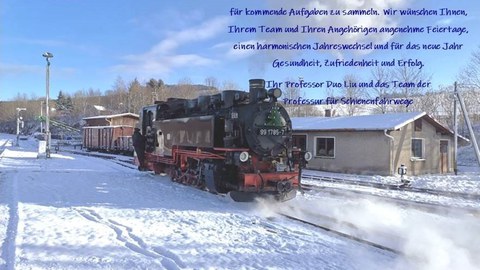 Eine Lok, die in einer verschneiten Winterlandschaft vor dem Lokschuppen steht. 