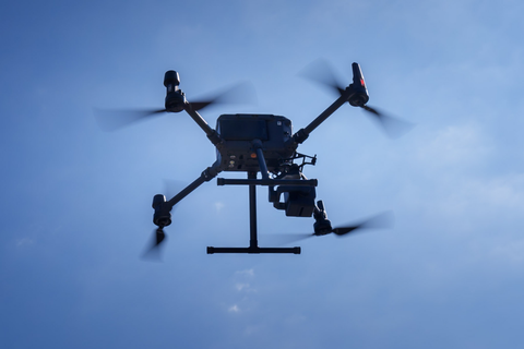 Foto einer fliegenden Drohne am blauen Himmel