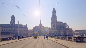 Das Bild zeigt die Augustusbrücke mit unterschiedlichen Verkehrsteilnehmenden. Auf dem Bild sind Zufußgehende, Radfahrende und eine Straßenbahn zu sehen.