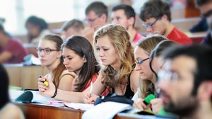 The picture shows students in a lecture hall.