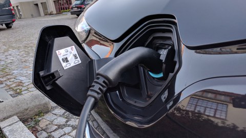 Zu sehen ist ein Elektroauto, welches gerade geladen wird. 