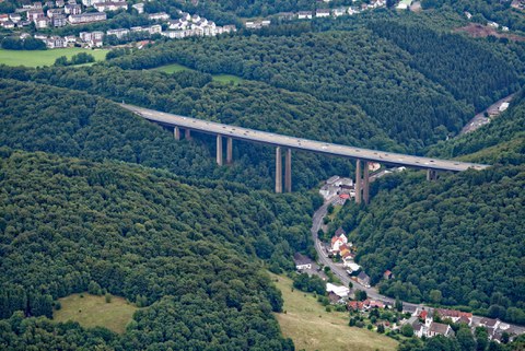Das Bild zeigt die Rahmedetalbrücke bei Lüdenscheid. Diese überspannt ein Tal mit der dort liegenden Hauptstraße und einer Siedlung