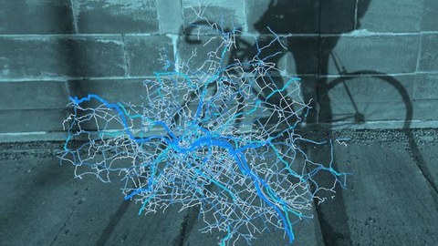 Zu sehen ist eine Heatmap mit den Radverkehrsströmen in Dresden sowie im Hintergrund der Schatten eines Fahrrads