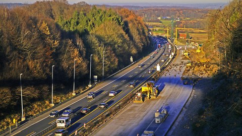 Autobahnbaustelle: Auf der linken Fahrbahn rollt der Verkehr, auf der rechten Fahrbahn ist eine Baustelle