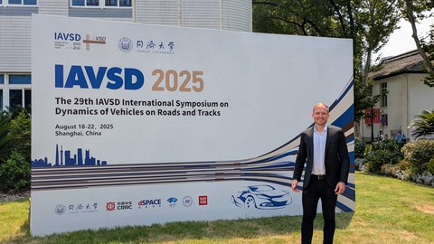 Tobias Schramm steht vor einer Tafel der IAVSD Konferenz in Shanghai