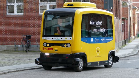 Ein kleiner gelber Bus der Berliner Verkehrsbetriebe, der autonom fährt.